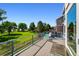 Open-air back deck with glass railing and exterior views of the landscaped yard and mature trees at 4814 S Upham Ct, Littleton, CO 80123