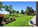 Spacious backyard featuring lush green lawn, mature trees, and partial views of the lake with a wooden fence at 4814 S Upham Ct, Littleton, CO 80123