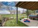 Backyard view featuring covered patio with hot tub, outdoor seating, and a well-maintained lawn, offering a private oasis at 4814 S Upham Ct, Littleton, CO 80123