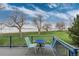 Scenic backyard view from the deck with chairs and a small table, overlooking a peaceful lake at 4814 S Upham Ct, Littleton, CO 80123