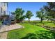 Landscaped backyard with patio, spiral staircase, manicured lawn, and mature trees at 4814 S Upham Ct, Littleton, CO 80123