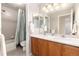 Well-lit bathroom featuring dual sinks, a toilet, and a shower-tub combo at 4814 S Upham Ct, Littleton, CO 80123
