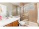 Bright bathroom with a walk-in shower, vanity, and neutral tile at 4814 S Upham Ct, Littleton, CO 80123