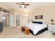 Large bedroom with neutral walls, ceiling fan, and a glimpse into the attached bathroom at 4814 S Upham Ct, Littleton, CO 80123