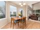 Bright dining area features large windows with lake views, wood floors, and seating for four at 4814 S Upham Ct, Littleton, CO 80123