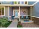 Welcoming front porch with seating, colorful flower pots, and a bright blue front door at 4814 S Upham Ct, Littleton, CO 80123