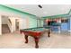 Spacious game room with a pool table, a kitchenette, and stairs leading to another level at 4814 S Upham Ct, Littleton, CO 80123