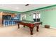 Bright game room featuring a pool table, kitchenette with bar seating, and sliding door to the outdoors at 4814 S Upham Ct, Littleton, CO 80123
