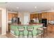 A kitchen with stainless steel appliances, wooden cabinets and a green breakfast bar with barstools at 4814 S Upham Ct, Littleton, CO 80123