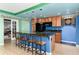 Cozy kitchenette with dark countertops, wood cabinets, a black refrigerator, and bar stool seating at 4814 S Upham Ct, Littleton, CO 80123