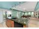 View of the open kitchenette with wood cabinets, dark counters, stainless steel appliances, and pool table at 4814 S Upham Ct, Littleton, CO 80123