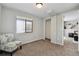 Simple bedroom with a patterned chair, window with light-filtering shade, and easy access to other areas at 19131 E Garden Pl, Centennial, CO 80015