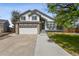Charming two-story home featuring a stone facade, attached two-car garage, and inviting front porch at 19131 E Garden Pl, Centennial, CO 80015