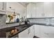 Close-up of a kitchen sink with white cabinets, granite countertops, and stylish backsplash at 19131 E Garden Pl, Centennial, CO 80015