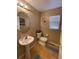 Compact bathroom featuring pedestal sink, toilet, and a window at 4614 Lyndenwood Cir, Highlands Ranch, CO 80130