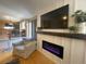 Modern living room with fireplace, mounted TV, and a view into the adjacent room at 4614 Lyndenwood Cir, Highlands Ranch, CO 80130