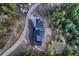Aerial view of home and driveway, surrounded by tall pine trees in wooded area at 21429 Trappers Trl, Morrison, CO 80465