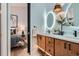 Stylish bathroom with double vanity, pendant lighting, wood cabinets, and connecting bedroom view at 21429 Trappers Trl, Morrison, CO 80465
