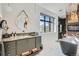 Bright bathroom featuring a vanity, a round mirror, and a standalone tub near a large window at 21429 Trappers Trl, Morrison, CO 80465