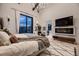 Beautiful bedroom featuring modern chandelier, large windows with natural light and decorative fireplace and television at 21429 Trappers Trl, Morrison, CO 80465