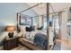 Cozy bedroom with four-poster bed, unique art, bedside table with lamp, and natural light at 21429 Trappers Trl, Morrison, CO 80465