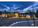 Stunning modern home with stone accents, large windows, and meticulous landscaping, set against a dramatic sky at 21429 Trappers Trl, Morrison, CO 80465