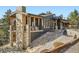 Custom exterior design with a stone chimney, outdoor deck, and unique architectural details at 21429 Trappers Trl, Morrison, CO 80465