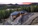 Stunning exterior with a modern design, beautiful stone accents, and mountain views at sunset at 21429 Trappers Trl, Morrison, CO 80465
