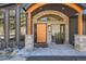 Stylish front entrance featuring a wood door, stone archway, and modern design at 21429 Trappers Trl, Morrison, CO 80465