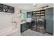Modern laundry room with high-end washer and dryer set, subway tile and dog bath at 21429 Trappers Trl, Morrison, CO 80465