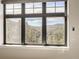 A stunning view of forest trees and mountains visible through a large window with a black frame at 21429 Trappers Trl, Morrison, CO 80465