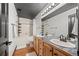 Bathroom featuring double vanity, wood floors, and a shower-tub combination at 1555 California St # 419, Denver, CO 80202