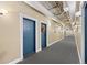 Hallway with two doors, carpeted floors, exposed pipes, and modern lighting fixtures at 1555 California St # 419, Denver, CO 80202