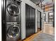 Stainless steel stacked washer and dryer are located next to the hallway with hardwood floors at 1555 California St # 419, Denver, CO 80202