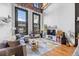 Bright living room with large windows, exposed brick, modern furniture, and a decorative geometric rug at 1555 California St # 419, Denver, CO 80202