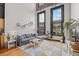 Bright living room featuring a comfortable gray sofa, large windows, and a stylish geometric rug at 1555 California St # 419, Denver, CO 80202