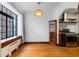 Dining room featuring large window, hardwood floors, decorative corner cabinet, and convenient access to kitchen at 1060 N Washington St # 103, Denver, CO 80203