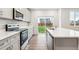 Bright kitchen features stainless steel appliances, an island, and backyard view at 1368 Orchard St, Brighton, CO 80601