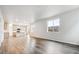 Open-concept living room featuring hardwood floors and a modern kitchen with an island at 1368 Orchard St, Brighton, CO 80601