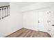 Bright entryway with hardwood floors, white walls, staircase and white door with black hardware at 2672 W 68Th Ave, Denver, CO 80221