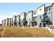 Modern townhomes feature gray siding, balconies, and contemporary architectural details on a sunny day at 2672 W 68Th Ave, Denver, CO 80221