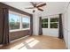 Bright bedroom featuring wood-paneled accent wall, hardwood floors, and multiple windows with backyard views at 11 W Ellsworth Ave # 22, Denver, CO 80223