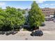 Street view highlighting the property with mature trees and city skyline views at 11 W Ellsworth Ave # 22, Denver, CO 80223