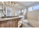 Well-lit bathroom featuring granite counters, wooden cabinets, and a combined shower and tub at 6493 W 98Th Ct, Westminster, CO 80021