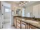 Light filled bathroom features double sinks, granite countertops, and an entrance into a walk-in closet at 6493 W 98Th Ct, Westminster, CO 80021