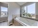 Large soaking tub sits under a window, providing natural light and scenic views at 6493 W 98Th Ct, Westminster, CO 80021