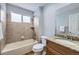 Cozy bathroom with tiled shower-tub combo, wood cabinets, and stone countertop at 6493 W 98Th Ct, Westminster, CO 80021