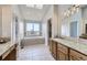 Bright bathroom with double sinks, granite countertops, a large window, and a soaking tub at 6493 W 98Th Ct, Westminster, CO 80021