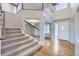 Bright foyer featuring hardwood floors, a staircase with white railings, and a view into the living spaces at 6493 W 98Th Ct, Westminster, CO 80021