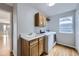 Functional laundry room with a sink, washer, dryer, and wooden cabinets at 6493 W 98Th Ct, Westminster, CO 80021